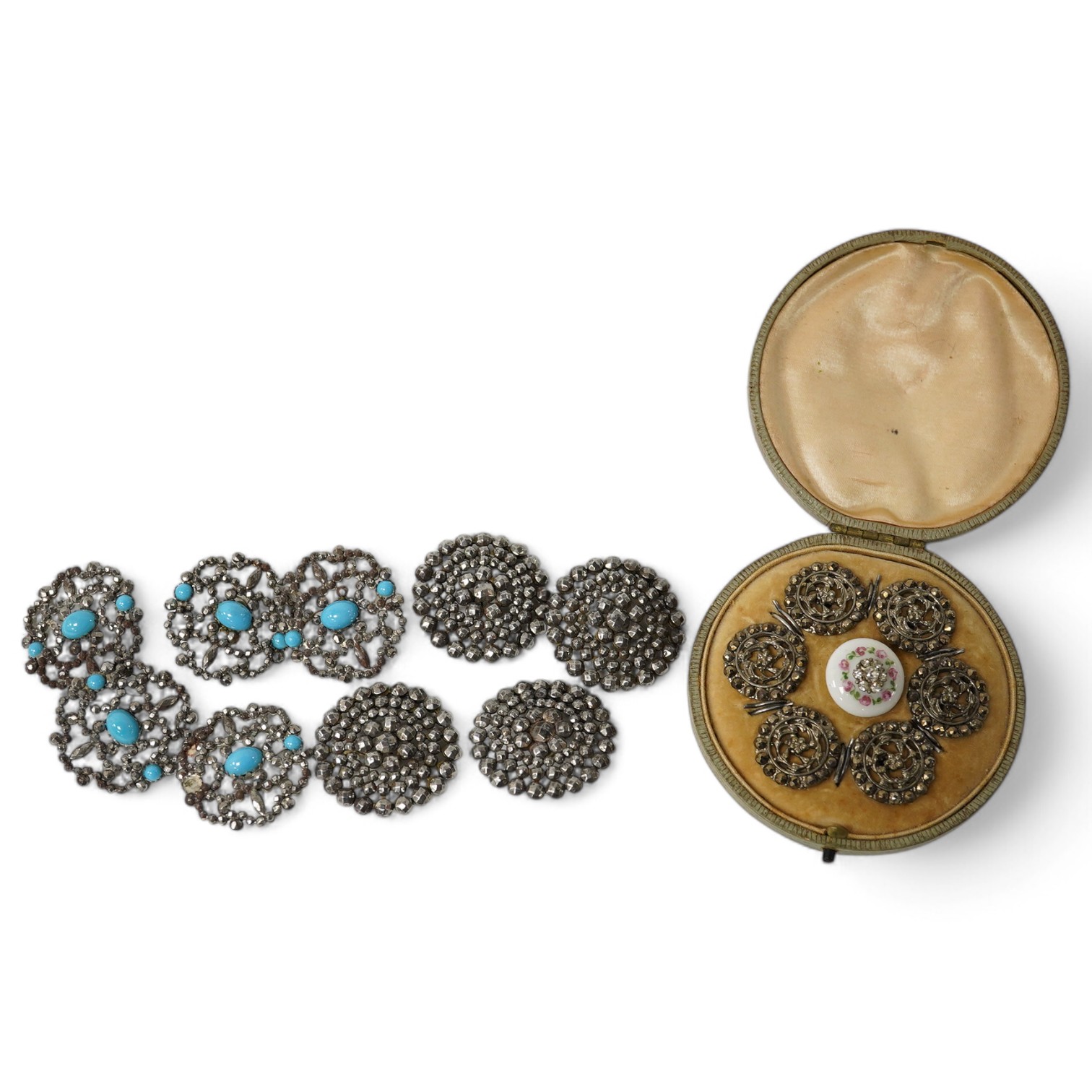 An Edwardian cased set of 6 cut steel buttons with central floral motifs, 20mm, a paste inset ceramic button, a set of 4 cut steel buttons, 33mm and a set of 5 cut steel and simulated turquoise buttons, 33mm. Condition -